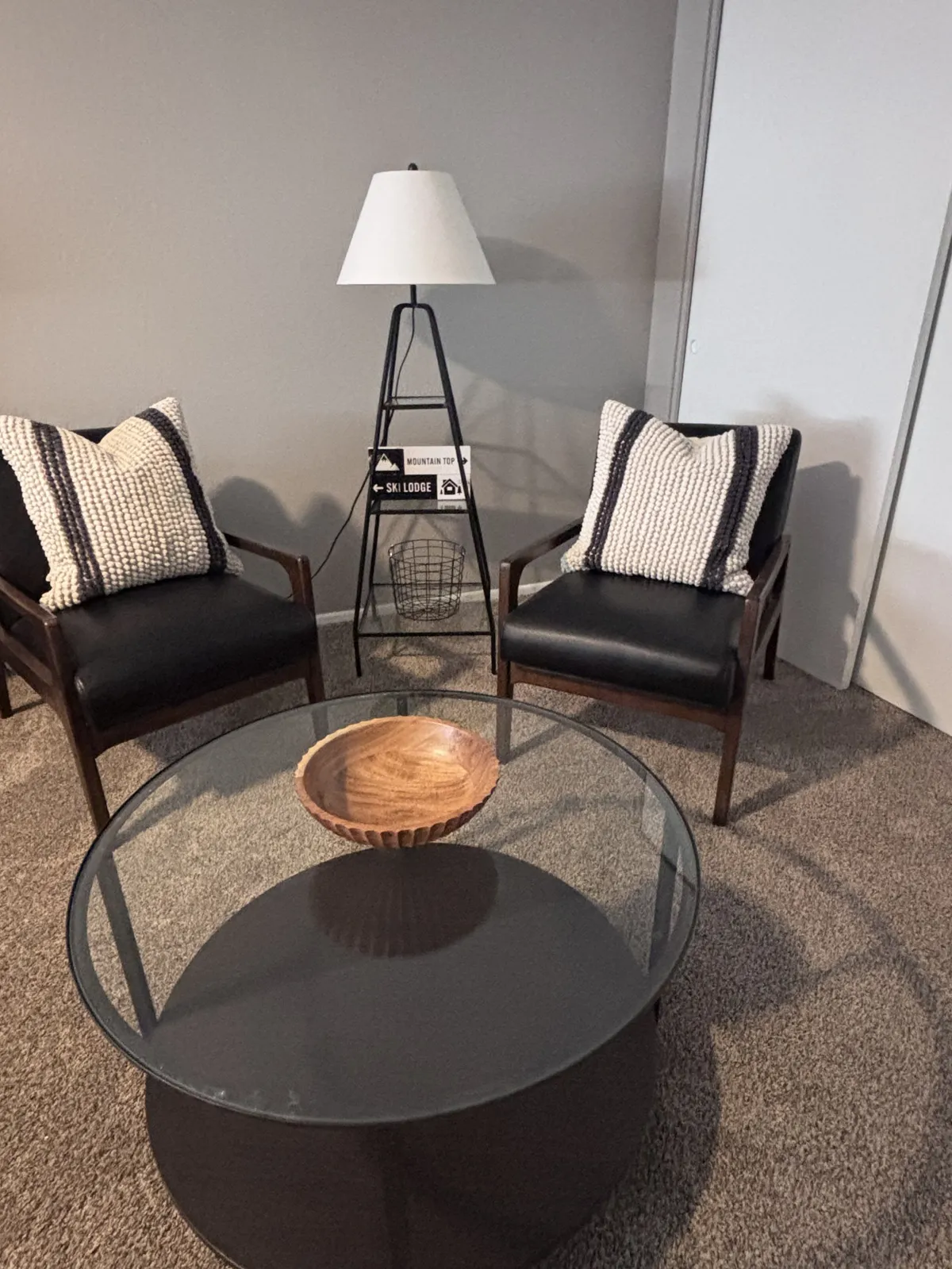 This image features two inviting armchairs placed near a lamp and a wooden bowl, creating a cozy nook for conversation or relaxation. The warm lighting and arrangement suggest an atmosphere perfect for unwinding or sharing intimate moments, with design elements that evoke comfort and connection.